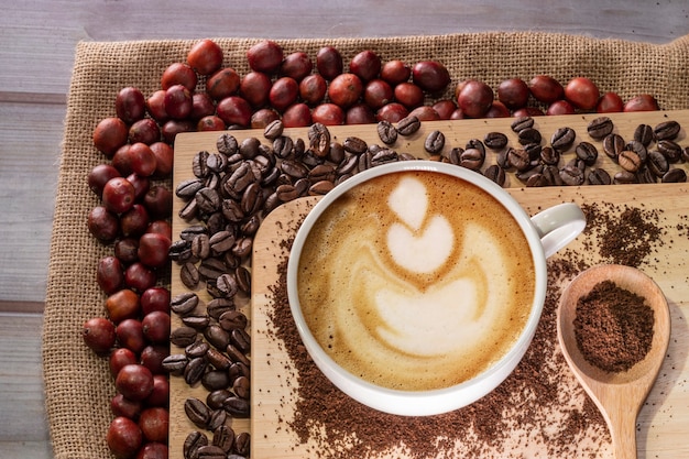 Tiro superior de la taza de café con leche y granos de café