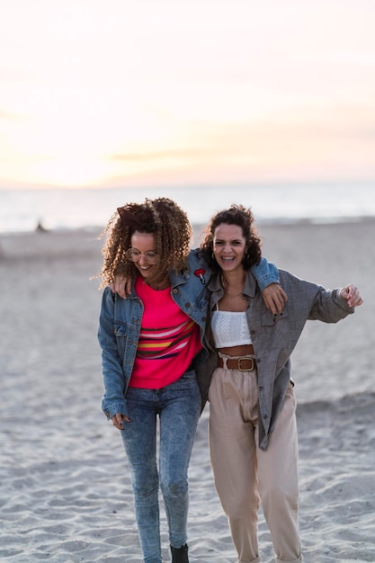 Tiro vertical de duas mulheres caucasianas espanholas posando na areia