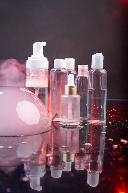 Tiro vertical de garrafas cosméticas transparentes conceito de publicidade de cosméticos bolha rosa e vapor