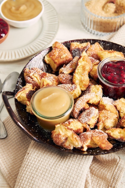 Tiro vertical de kaiserschmarrn com panquecas rasgadas, geléia de cranberries e purê de maçã em uma mesa