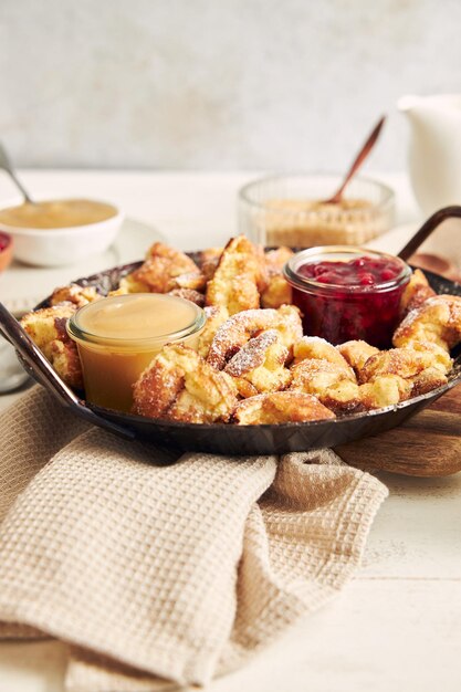 Tiro vertical de kaiserschmarrn com panquecas rasgadas, geléia de cranberries e purê de maçã em uma mesa