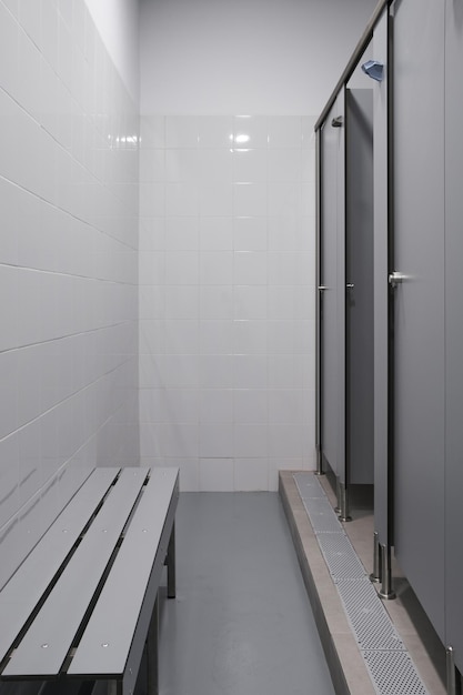 Tiro vertical de um banheiro vazio com paredes de azulejos brancos