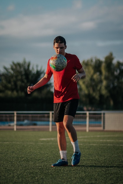 Tiro vertical de um jogador fazendo toques com os pés no campo de futebol.