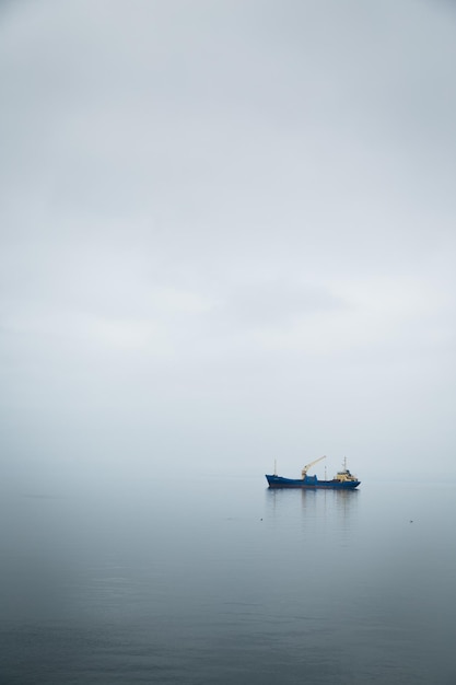 Tiro vertical de um navio no mar coberto de neblina