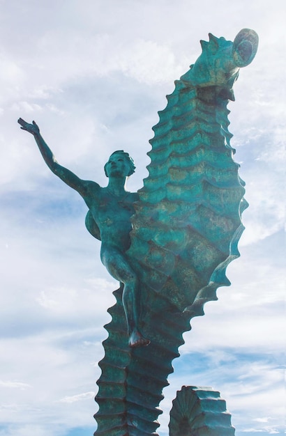 Tiro vertical de uma estátua de cavalo-marinho contra o céu em Puerto Vallarta