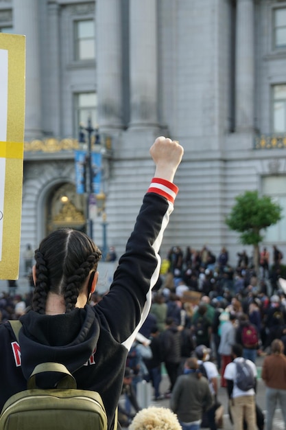 Tiro vertical de uma mulher com o punho cerrado durante o protesto black lives matter