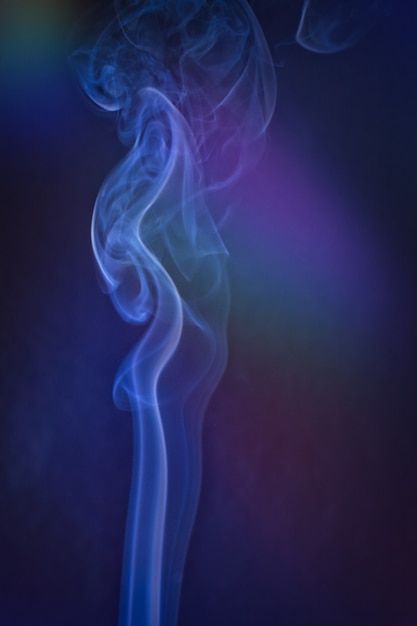 Un tiro vertical de humo con retroiluminación colorida con una nota azul