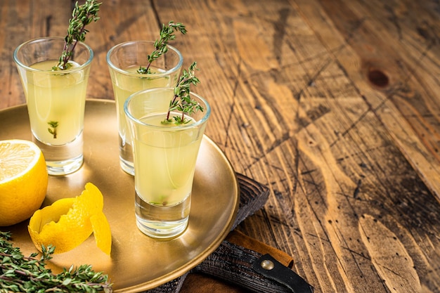 Tiros de limoncello Licor de limão italiano Fundo de madeira Vista superior Copiar espaço