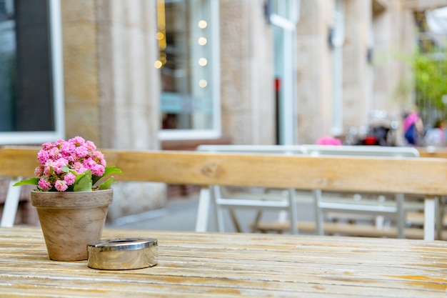 Tisch antike Holzterrasse mit einem Aschenbecher und einer hübschen Pflanze rosa Blumen