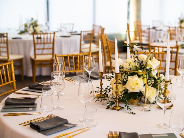 Tisch bei Luxus-Hochzeitsfeier schöne Blumen auf dem Tisch und Serviergeschirr und Gläser an