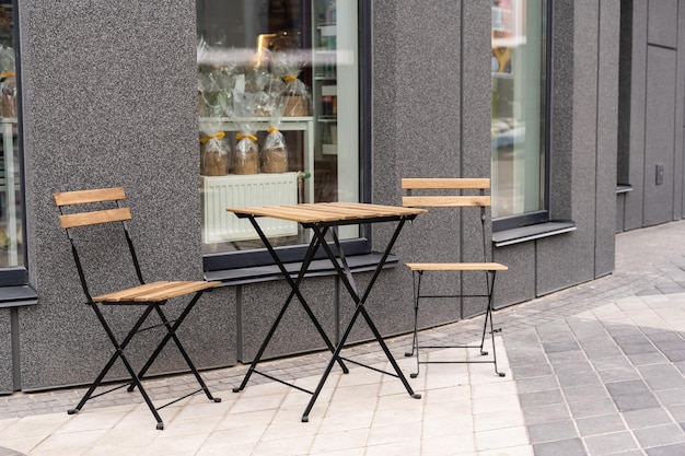 Tisch im Freien und zwei Stühle in der Nähe der Wand im Café,