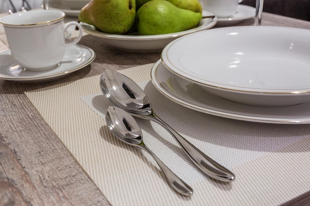 Tisch in der Küche mit Tellern aus Gläsern und grünen Birnen