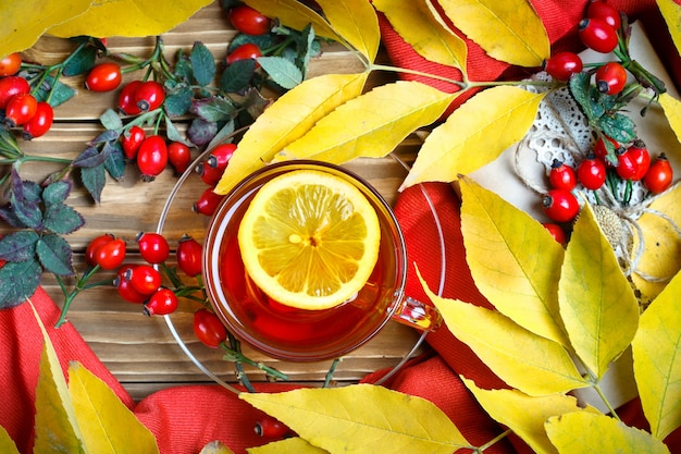 Tisch mit herbstlaub, beeren und frischem tee dekoriert