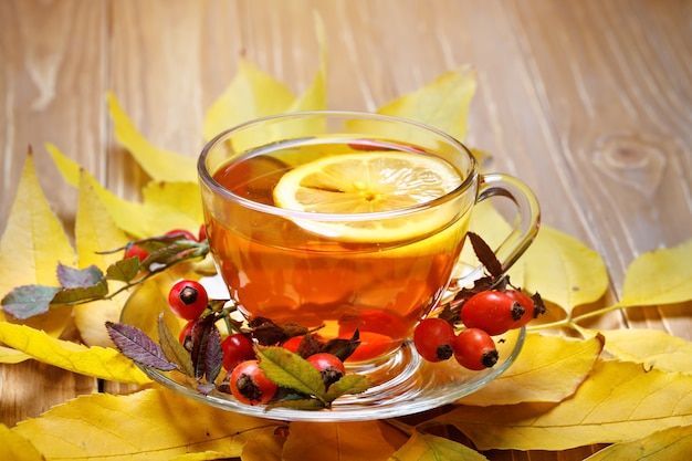 Tisch mit Herbstlaub, Beeren und frischem Tee dekoriert