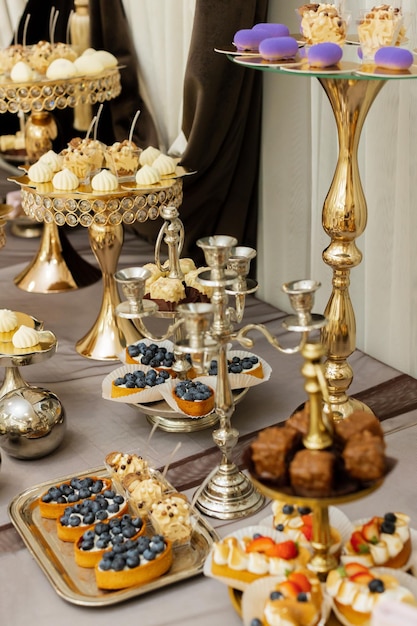 Tisch mit Kuchen, Süßigkeiten, Bonbons, Buffet, Desserttisch für eine Party, Leckereien für den Hochzeitsbankettbereich, Nahaufnahme, Schokoriegel, dekoriert köstlich