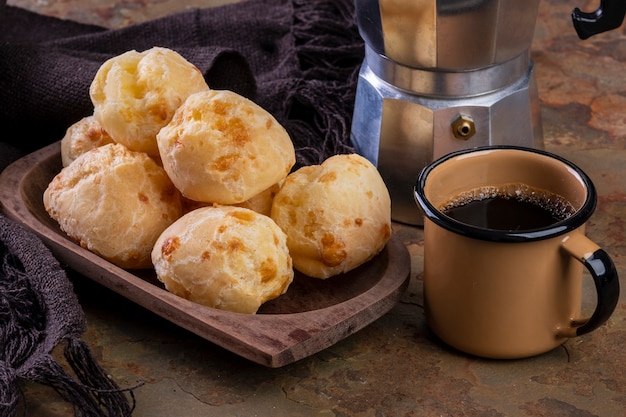 Tisch mit leckeren Käsebroten, einer Kaffeetasse und einer traditionellen Kaffeemaschine.