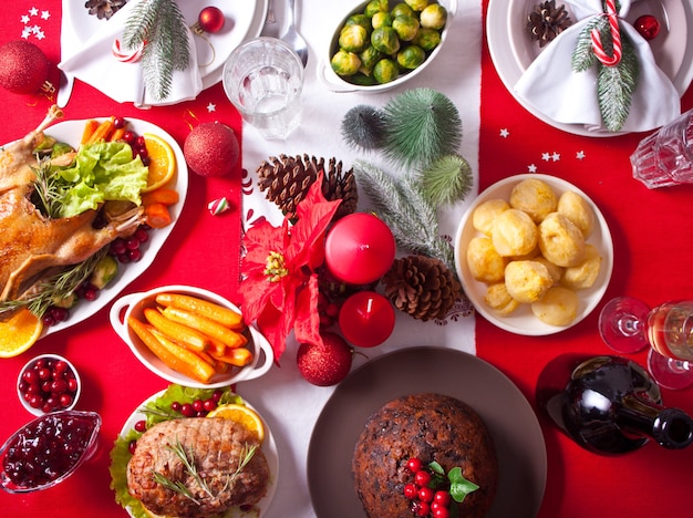 Tisch zum Erntedankfest oder Weihnachtsessen. Gefüllter gebratener Truthahn im Vordergrund. Traditioneller Feiertag. Draufsicht.