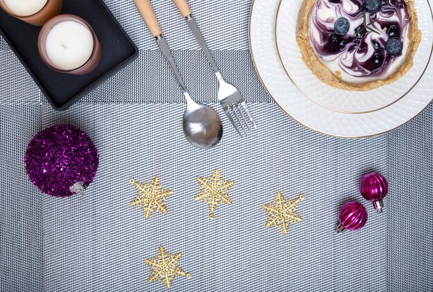 Tischdekoration für das Weihnachtsessen mit einem Stück Blaubeer-Käsekuchen