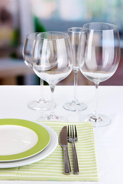 Tischdekoration mit Gläsern für verschiedene Getränke auf dem Tisch auf Raumhintergrund