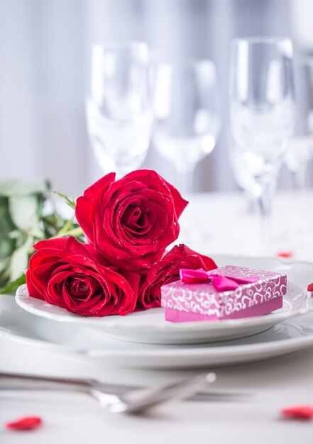 Tischdekoration zum Valentinstag oder Hochzeitstag mit roten Rosen Romantische Tischdekoration für zwei
