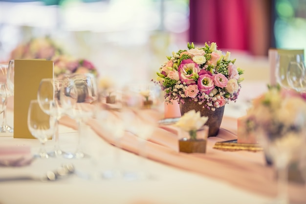 Tischdekoration zur Hochzeit. Wunderschöner Tisch mit Blumen und Glasbechern für eine festliche Veranstaltung, Party oder Hochzeitsfeier.