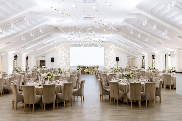 Tische an einem luxuriösen Hochzeitstisch für Gäste Gerichte und Getränke Blumenschmuck weiße Stühle und Tisch Hochzeitstisch Vorbereitung Draufsicht Horizontales Foto