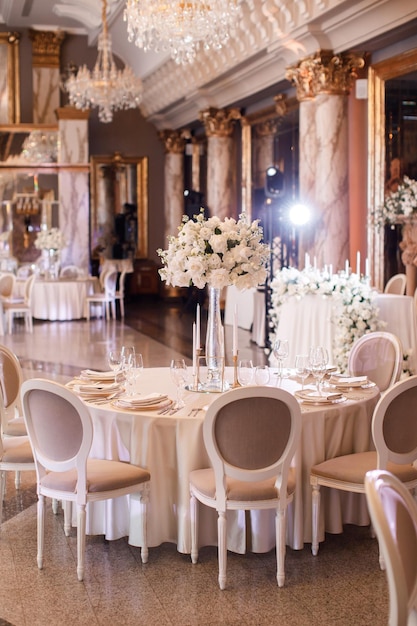 Tische an einem luxuriösen Hochzeitstisch für Gäste Gerichte und Getränke Blumenschmuck weiße Stühle und Tisch Hochzeitstisch Vorbereitung Draufsicht Horizontales Foto