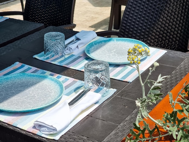 Tische mit weißer Tischdecke und Stühlen in Restaurantgläsern auf dem Tisch. Leere Cafétische auf der Veranda des Restaurants, Freizeitreise- und Tourismuskonzept, servierter Tisch im Open-Air-Restaurant am Strand