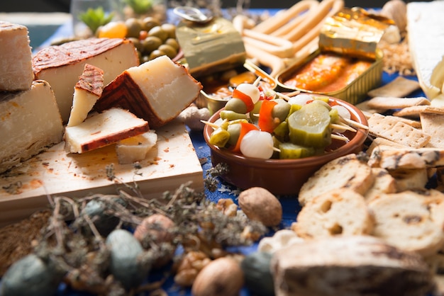 Tischgarnitur mit Aperitif bestehend aus verschiedenen Speisen Käse und Dosen Essiggurken