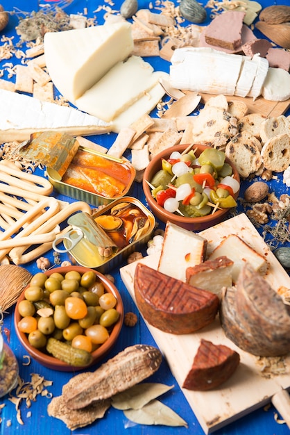 Tischgarnitur mit Aperitif bestehend aus verschiedenen Speisen Käse und Dosen Essiggurken