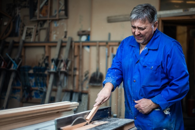 Tischler bei der Arbeit in seiner Werkstatt, Holzverarbeitung