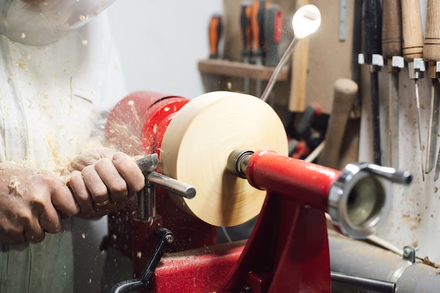 Tischler, der ein Stück Holz auf der Drehbank formt