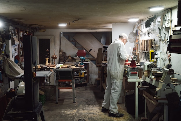 Foto tischler, der ein stück holz auf der drehbank formt