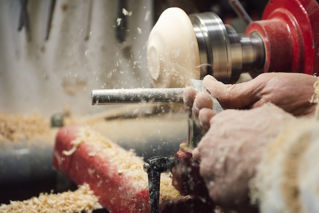 Tischler, der ein Stück Holz auf der Drehbank formt