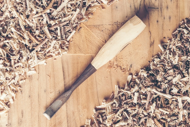 Foto tischlerwerkzeuge auf holztisch mit sägemehl. draufsicht des tischlerarbeitsplatzes