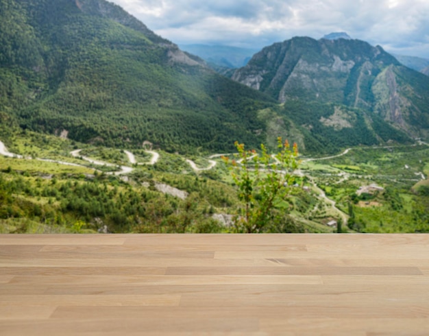 Tischplatte aus Eichenholz mit freiem Platz für die Installation eines Produkts oder Layouts auf dem Hintergrund einer Bergsommerlandschaft