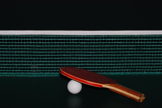 Tischtennis schlaeger ball und netz auf tischtennistisch grossansicht gerade view