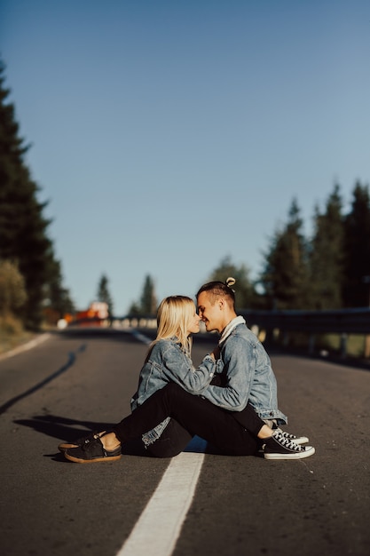 Título Pareja sentada en la carretera.