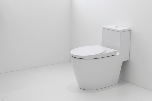 Foto toalete nivelado branco no banheiro branco.