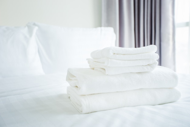 Foto toalha branca na cama branca no quarto de cama