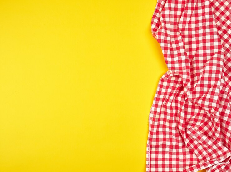 Foto toalha de cozinha vermelha em uma gaiola em um fundo amarelo