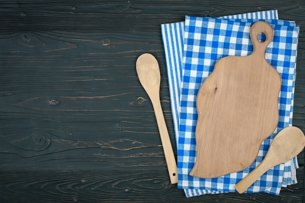 Toalha de mesa quadriculada azul e utensílios de madeira para cozinhar e assar. com espaço de cópia. Horizontal.