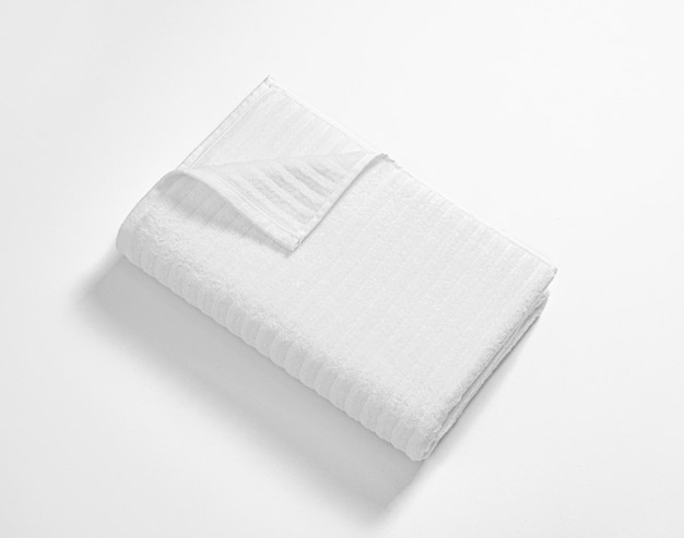 Foto toalha de terry macia branca dobrada contra o fundo branco