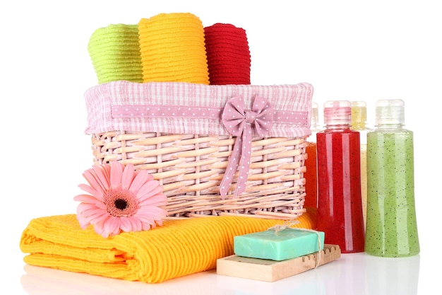 Foto toalhas coloridas em garrafas de cosméticos de cesta e sabão isolado em branco