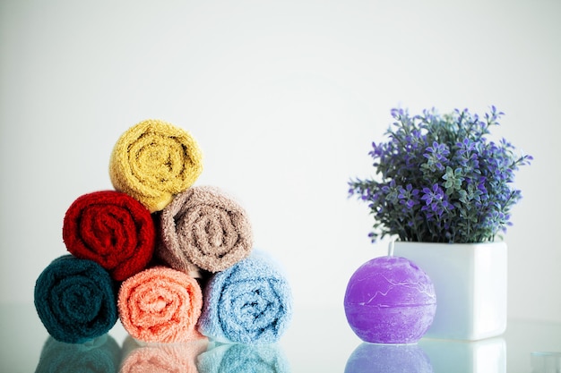 Toalhas coloridas na mesa branca com espaço de cópia no fundo da sala de banho.