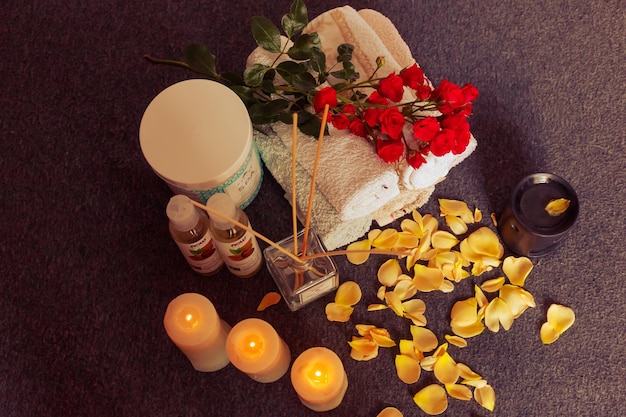 Toalhas com flores secas e velas para uma massagem relaxante no spa e cuidados com o corpo Composição com creme de massagem com óleo de amêndoa