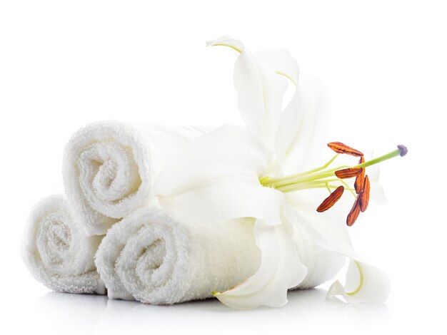 Toalhas de spa brancas com flor de lírio isoladas em branco. Conceito de spa