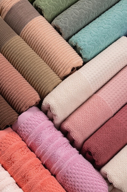 toalhas felpudas multicoloridas enroladas e dispostas em uma fileira sobre a mesa
