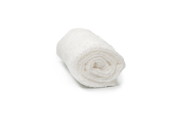 Toalla de algodón esponjoso blanco aislado en una superficie blanca. Spa y resort.