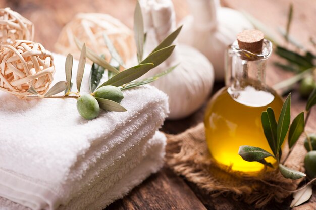 Toalla de baño y jabón de aceite de oliva en la mesa de madera